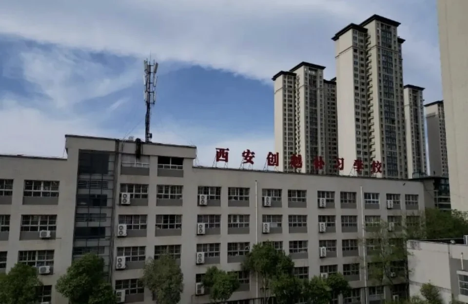 西安创越补习学校教学楼外景，楼顶有红色校名标识